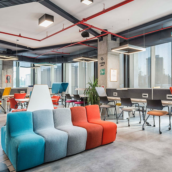 Modern couch in shades of teal, gray, and orange, featuring a contemporary design within a stylish office setting.