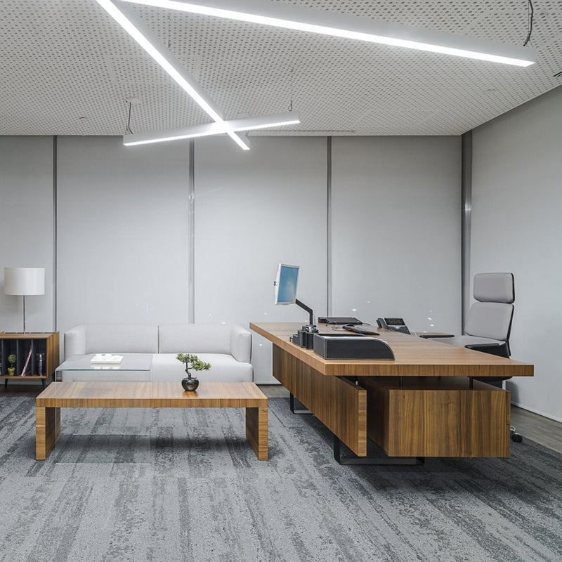 Modern office space with light gray walls, sleek wooden furniture, and a textured gray carpet, featuring clean lines and minimalist design.