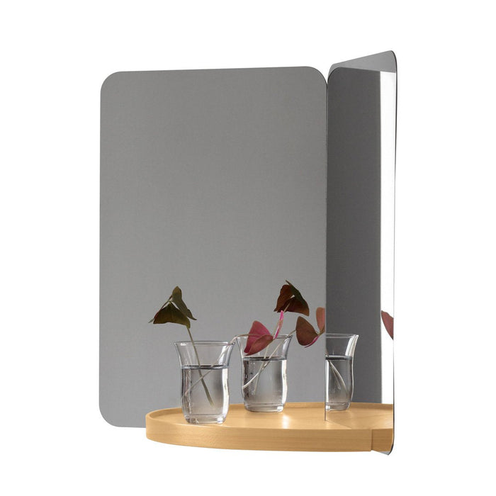 Modern wall mirror with sleek gray surface and natural wood base, showcasing minimalist design and soft, neutral colors.