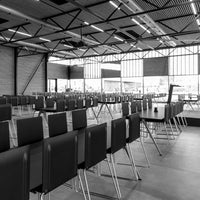 Black and white pattern of stacked chairs in a modern industrial space, highlighting sleek lines and minimalistic design.