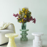 Colorful, patterned accent tables in yellow, green, and white, featuring a modern design perfect for home decor.