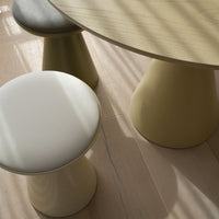"Modern dining set featuring a round light wooden table and two colorful stools in white, olive green, and light yellow."