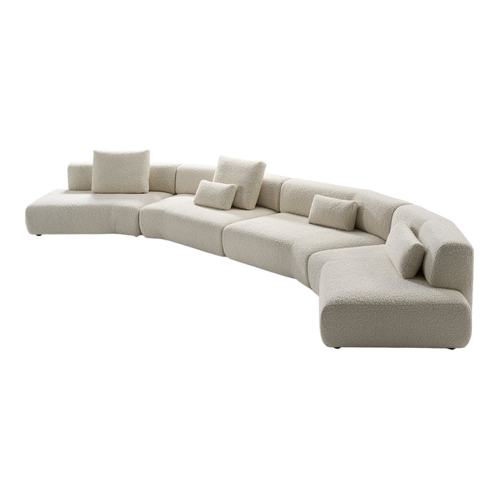 Curved, modern sofa in beige with plush cushions, featuring a soft, textured fabric and seamless design.