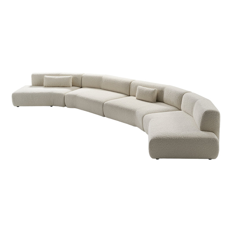 Curved sectional sofa in soft cream upholstery with minimalist design and subtle, smooth texture. Perfect for modern decor.