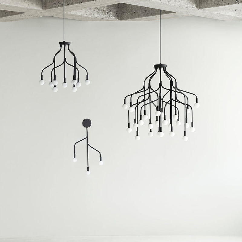 Black modern chandeliers with minimalist branch designs and white bulb accents, set against a neutral backdrop.