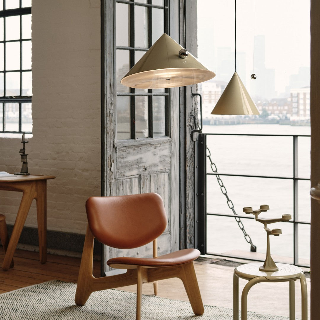 Modern room featuring beige pendant lamps, a brown leather chair, and neutral tones with natural wood accents.