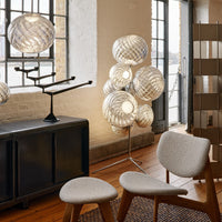 Contemporary decor featuring metallic and soft beige tones with patterned lighting fixtures and wooden accents.