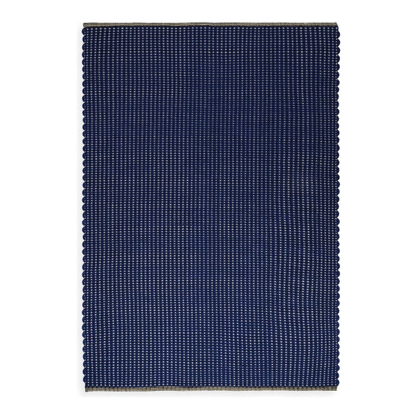 Navy blue rectangular rug with a subtle striped pattern and scalloped edges, adding texture and style.