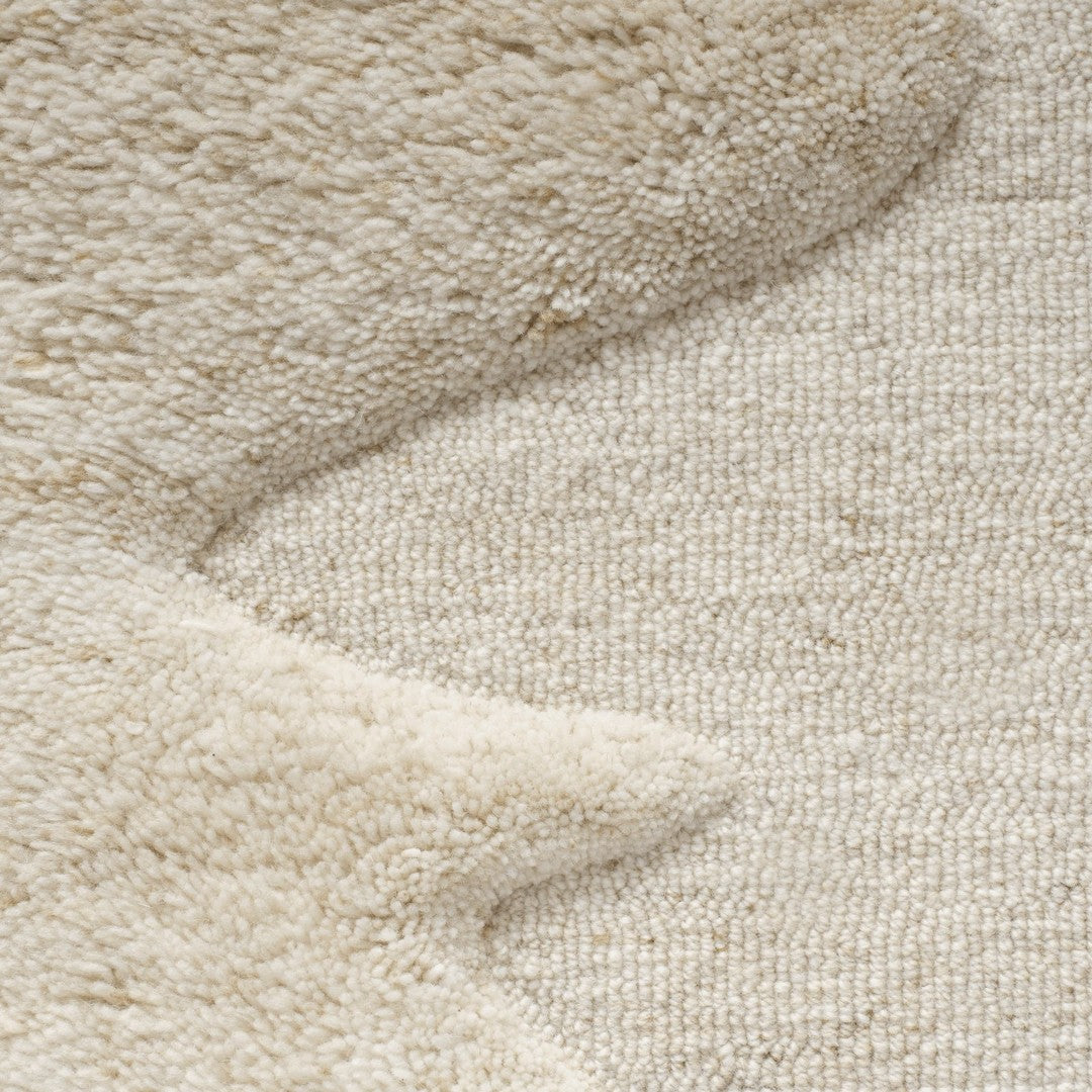 Beige textured rug featuring soft, wavy patterns and a plush finish for a cozy interior accent.