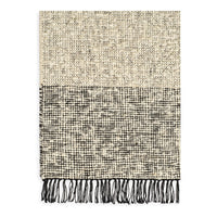 Textured beige and black patterned throw blanket with fringed edges.