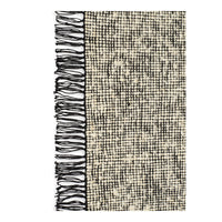 Textured beige and cream blanket with a black fringed edge and subtle checkered pattern. Perfect for cozy decor.