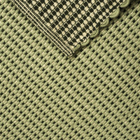 Green woven fabric with a black and cream checkered pattern and scalloped edge detail.