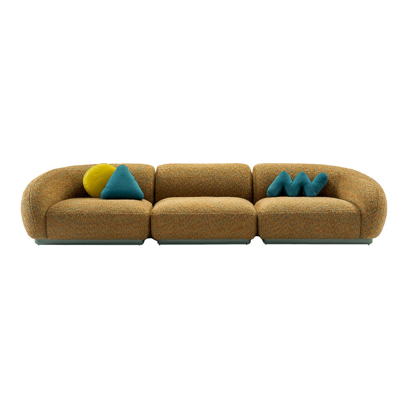 Textured orange sofa with turquoise and yellow accent pillows in playful geometric shapes.