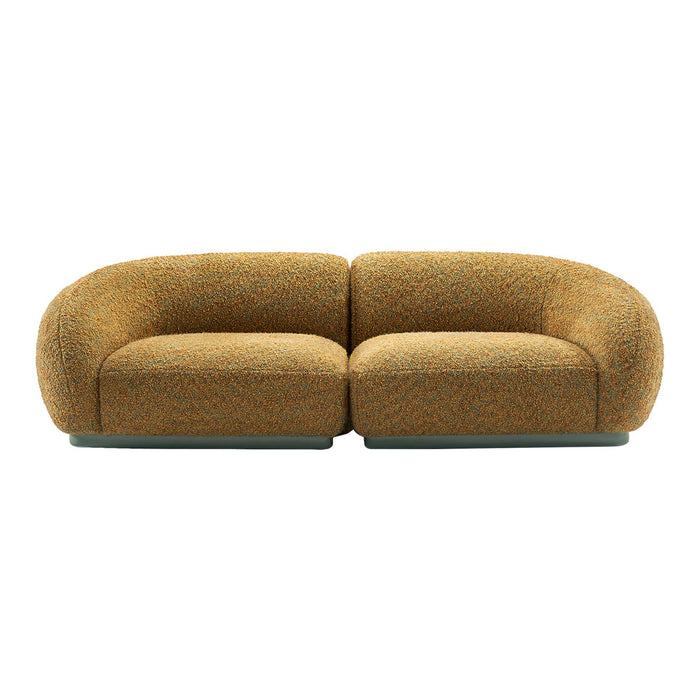 Curved two-tone sofa in warm orange and brown textured fabric with subtle multi-colored flecks.