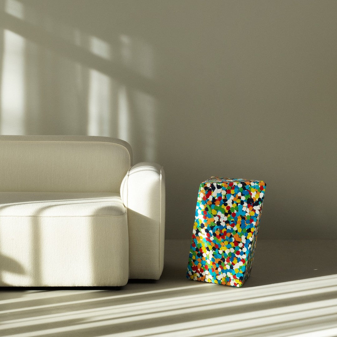 Colorful patterned accent piece featuring vibrant dots in blue, red, yellow, and white against a neutral background.