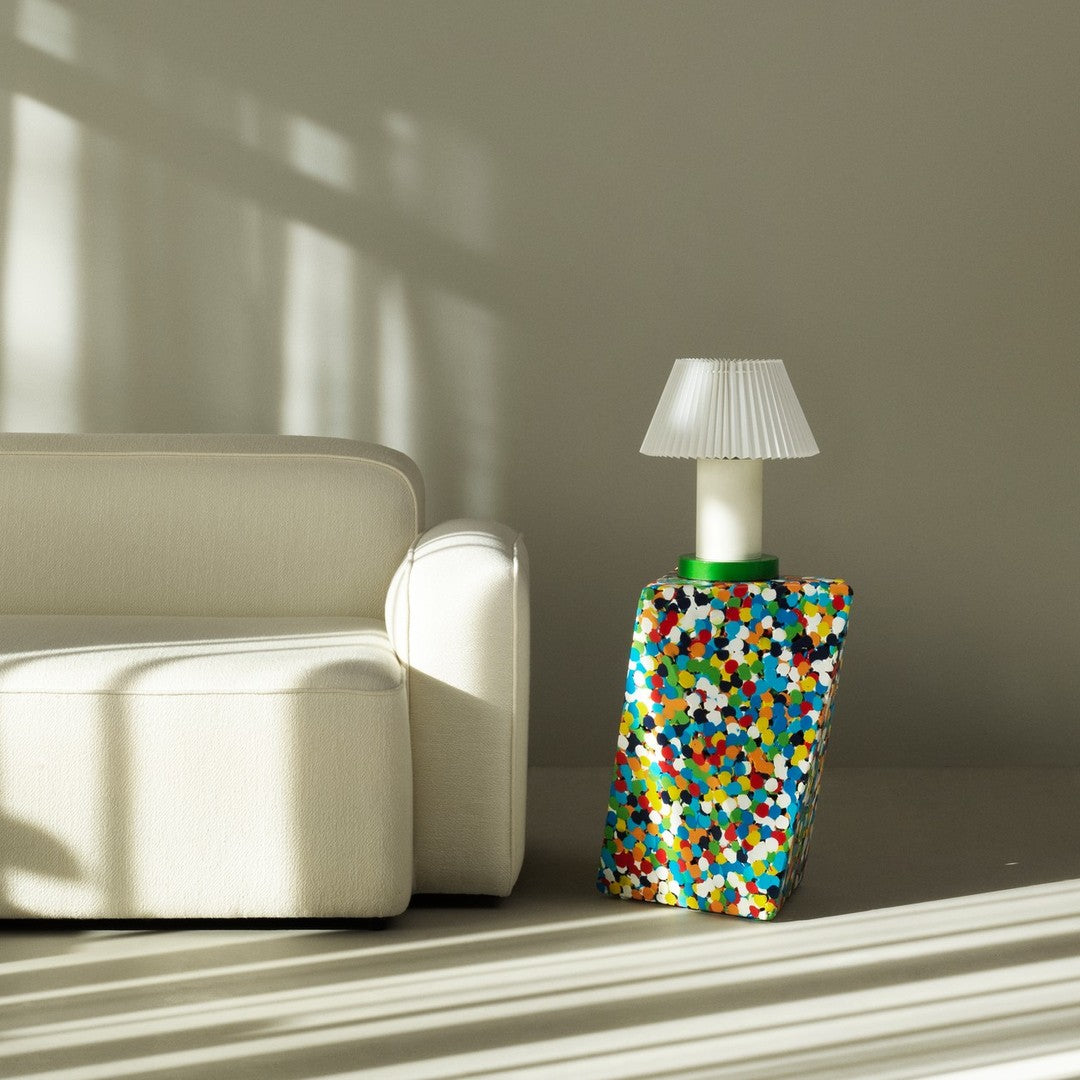 Colorful patterned lamp base with vibrant dots in blue, green, orange, and white against a neutral background.