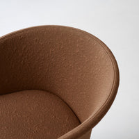 Brown textured fabric armchair with a smooth, curved design against a light background.