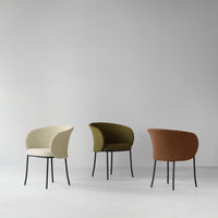 Three stylish chairs in cream, olive green, and terracotta, featuring textured upholstery and sleek black legs.