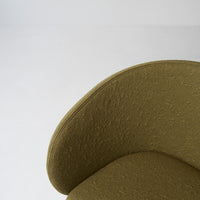 Olive green textured chair with a smooth, rounded silhouette on a minimalistic gray background.