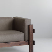Brown fabric couch with dark wood frame and minimalist design, featuring soft textures and natural tones.