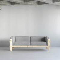 Gray upholstered sofa with light wood frame, featuring a minimalist design in a modern space.