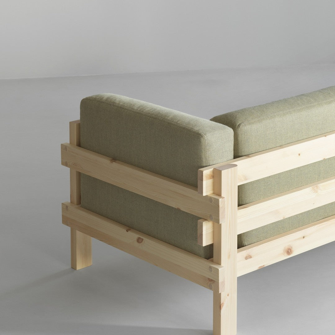 Green fabric cushions on a wooden frame, showcasing a minimalist design with natural textures and muted colors.