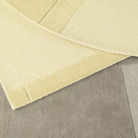 "Soft yellow and gray textured fabrics layered together, showcasing a cozy, minimalist design."