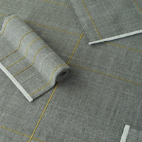 Gray fabric with yellow geometric patterns and stripes, featuring subtle textures and a modern design.