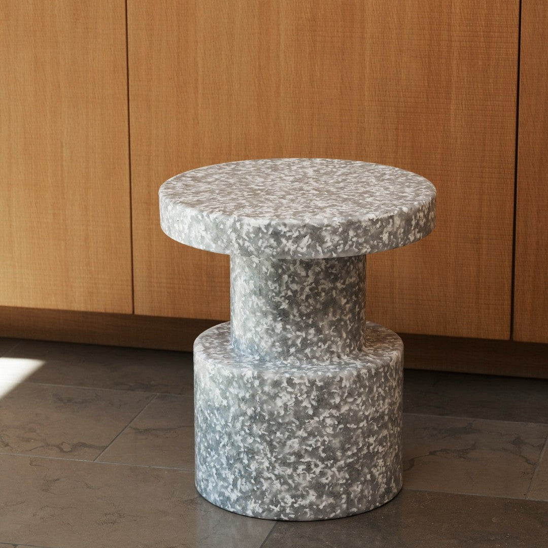 Gray speckled stone side table with a cylindrical base and rounded top, showcasing a modern and textured pattern.