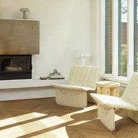 Neutral-toned quilted chairs with textured patterns, set against a light-filled modern interior.