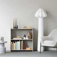 Modern bookshelf in neutral tones with white, yellow, and gray accents, featuring geometric shapes and minimalist decor.