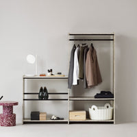 Minimalist wardrobe in natural wood and black accents, featuring neutral tones with a modern, sleek design.