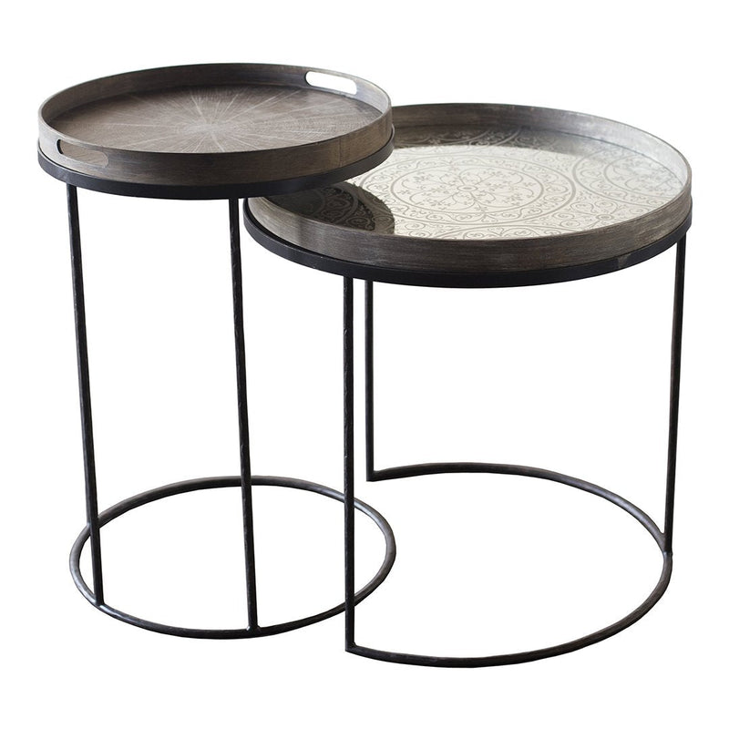 Two modern nesting tables with dark wood and intricate silver patterns on the trays, featuring sleek black metal bases.