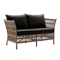 Textured gray wicker loveseat with two black cushions, showcasing a modern and stylish pattern. Ideal for outdoor spaces.