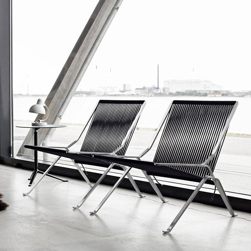 Modern black and white striped lounge chairs with sleek chrome frames, showcasing minimalistic design and elegance.