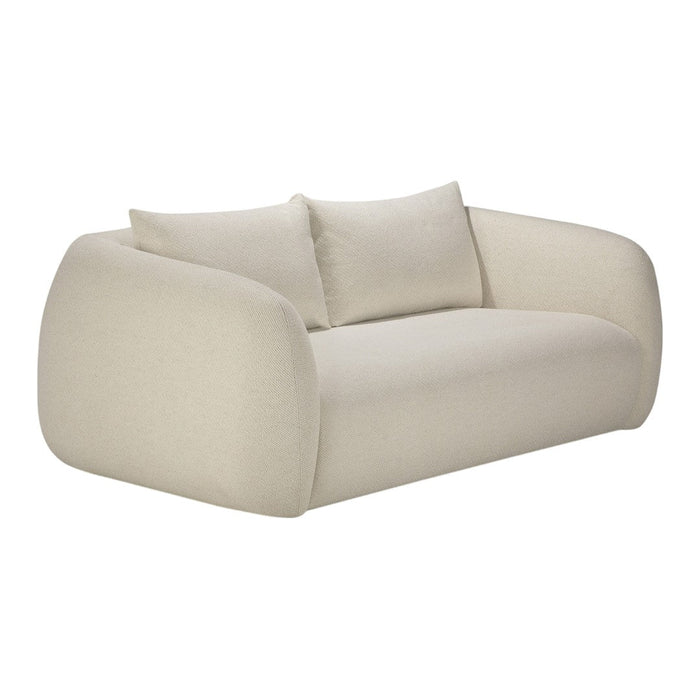 Beige curved sofa with smooth fabric and two matching cushions, offering a minimalist design and soft texture.