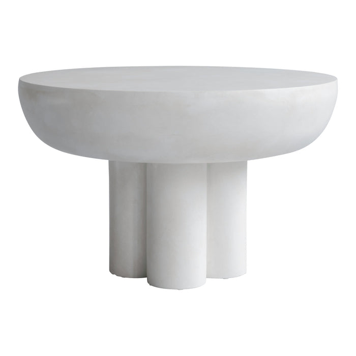 Round white concrete table with a smooth surface and four cylindrical legs, showcasing a minimalist design.