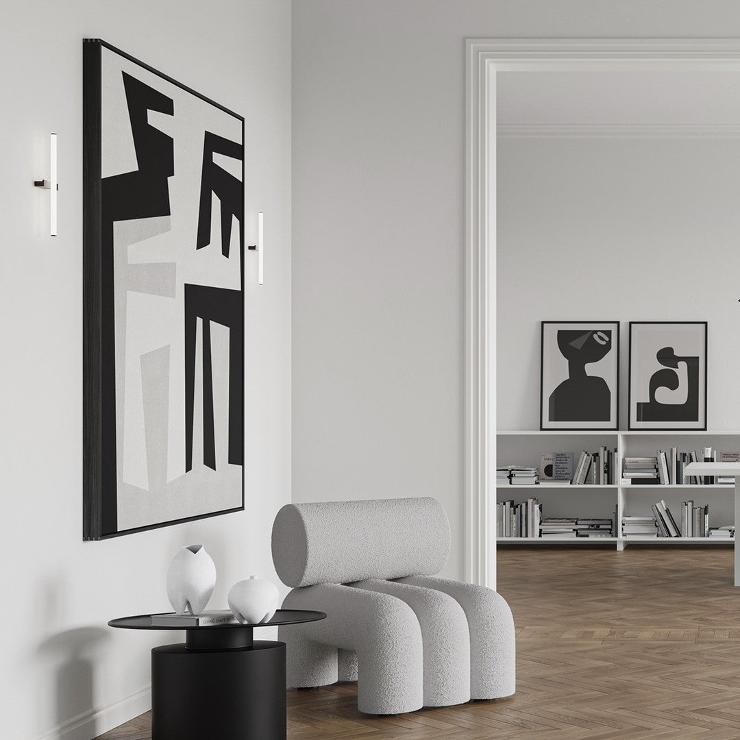 Modern black and white abstract wall art with geometric patterns, set in a minimalist gray interior.