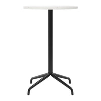 Round white tabletop with sleek black metal legs, featuring a modern minimalist design.