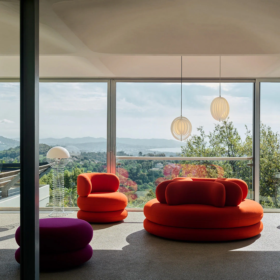 Vibrant orange and purple modern furniture with smooth fabrics, set against a bright, airy backdrop.