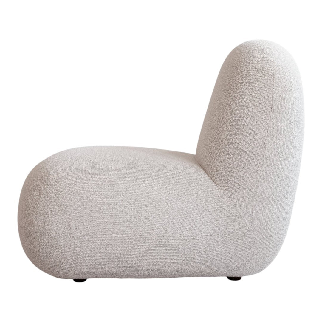 Textured beige lounge chair with soft curves, featuring a cozy, neutral color palette perfect for modern interiors.