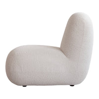 Textured beige lounge chair with soft curves, featuring a cozy, neutral color palette perfect for modern interiors.