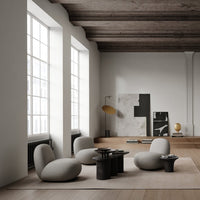 Modern room featuring soft gray furniture, black and white artwork, and warm wood accents under natural light.