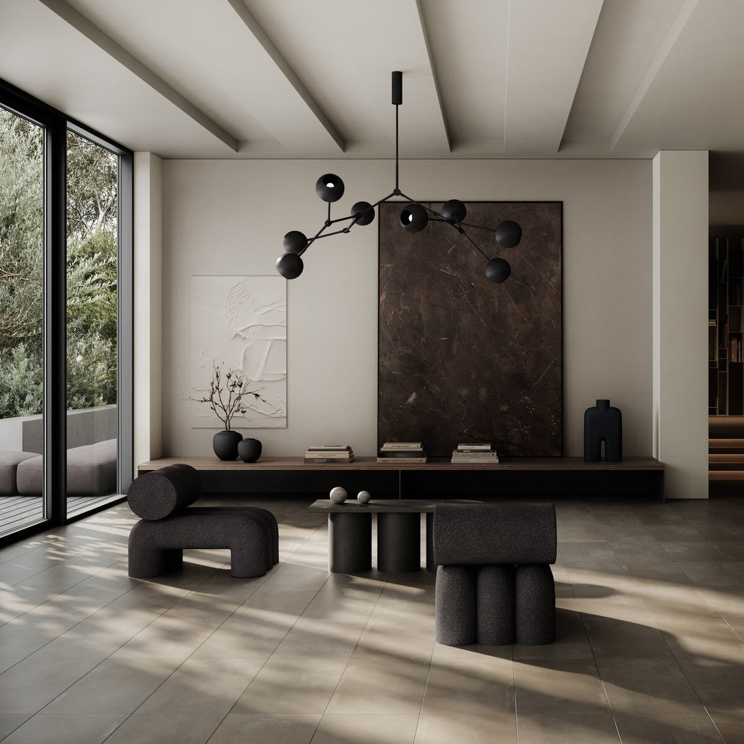 Modern living room featuring neutral tones with black and earthy accents, geometric patterns on soft furnishings.