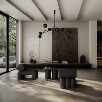 Modern living room featuring neutral tones with black and earthy accents, geometric patterns on soft furnishings.