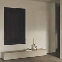 Black and dark maroon patterned wall hanging, adding rich texture to a minimalistic space.