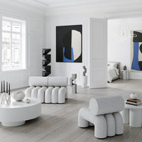 White sculptural furniture with gray tones and bold abstract black and blue wall art in a minimalist interior.