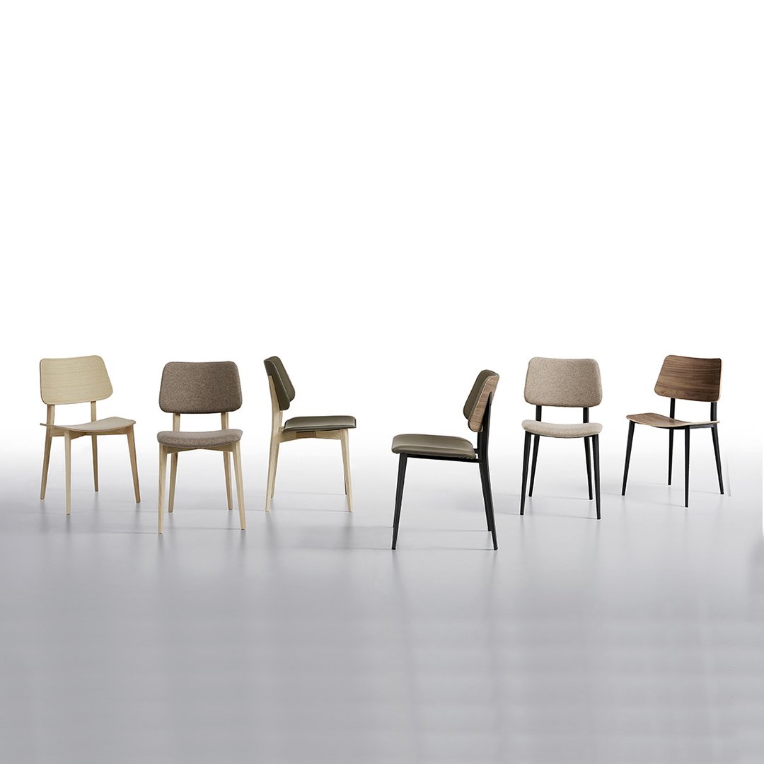 Set of six chairs in natural wood tones with various neutral and earthy upholstery colors. Modern, minimalist design.