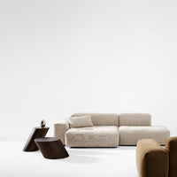 Beige modern sofa with soft texture, accompanied by dark wood side tables and warm brown accent pieces.
