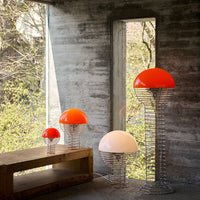 Modern floor lamps with vibrant orange and white domes, featuring sleek wire bases and a minimalist aesthetic.